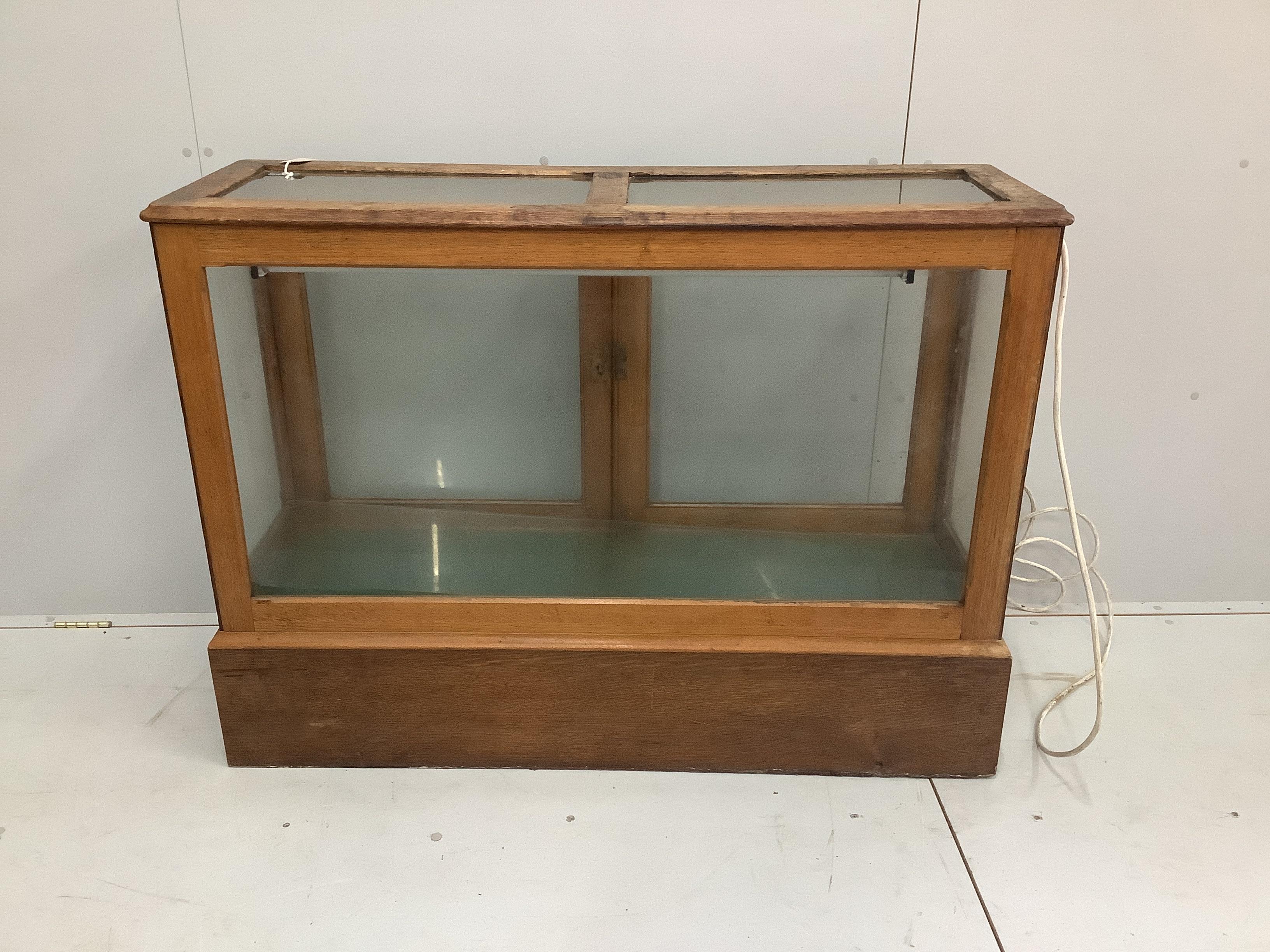 An early 20th century glazed oak shop display cabinet, width 124cm, depth 40cm, height 91cm